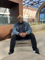 Jerome sitting in chair with urban surroundings
